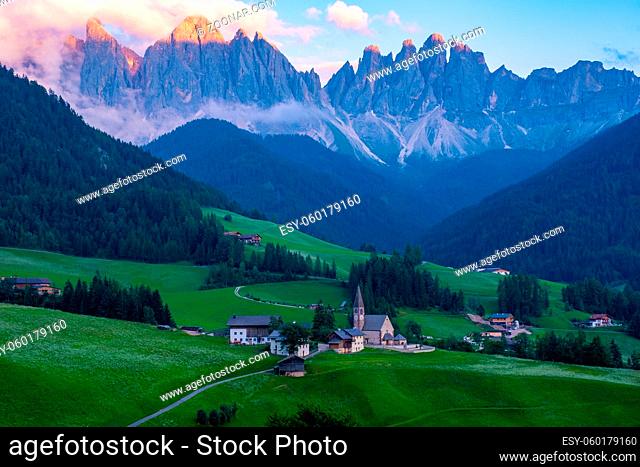 Santa Magdalena village in Val di Funes on the italian Dolomites. Autumnal view of the valley with colorful trees and Odle mountain group on the background