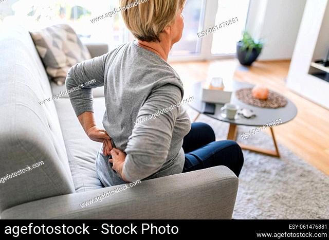 Elderly woman at home with lower back pain