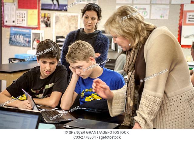 A perplexed Mission Viejo, CA, middle school science student gets assistance from a teacher as he gazes at a Google Chromebook laptop computer in STEM (Science