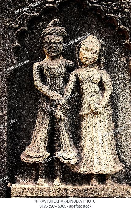 Indian couple , wife holding hand of the husband , carved on the wall of Ahilayabai temple , ornamental carving over stone , old Indian sculpture