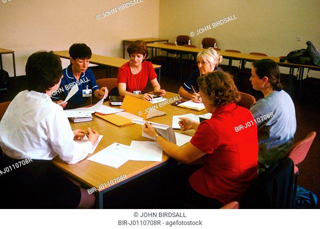 Various health workers sitting around table undergoing staff development training at the Queens Medical Centre, Nottingham