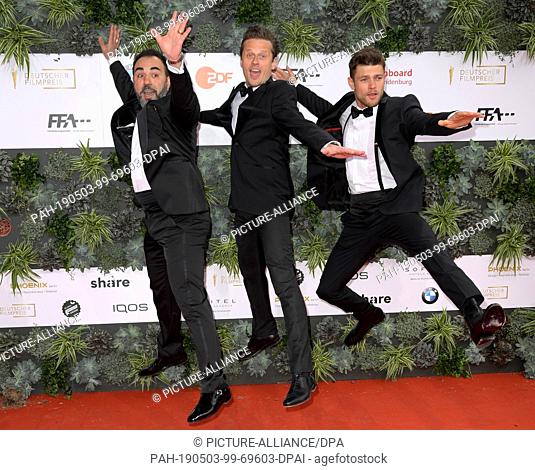 03 May 2019, Berlin: The actors Adnan Maral (l-r), Roman Knizka and Eugen Bauder jump into the air before the 69th German Film Prize ""Lola"" is awarded