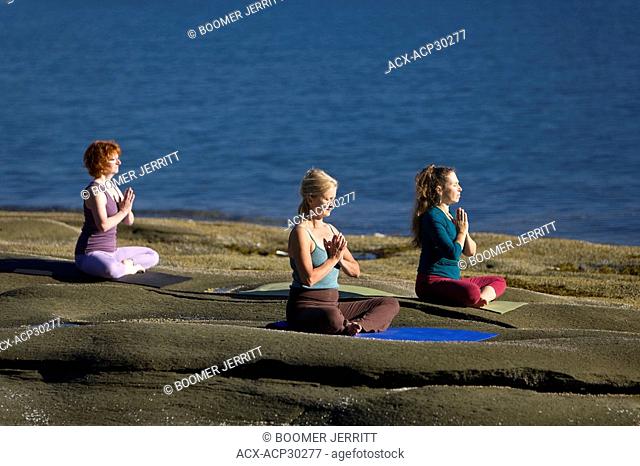 Yoga practioners on Denman Island meditate and relax in the lotus position. Denman Island, The Comox Valley, Vancouver Island, British Columbia, Canada