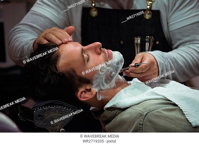 Man getting his beard shaved with razor