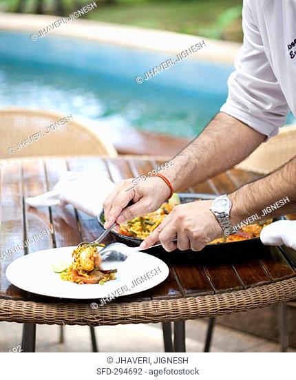 Paella being arranged on plates