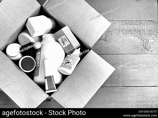 On a wooden table in a cardboard box bottles with medicines and cosmetics to send to the buyer