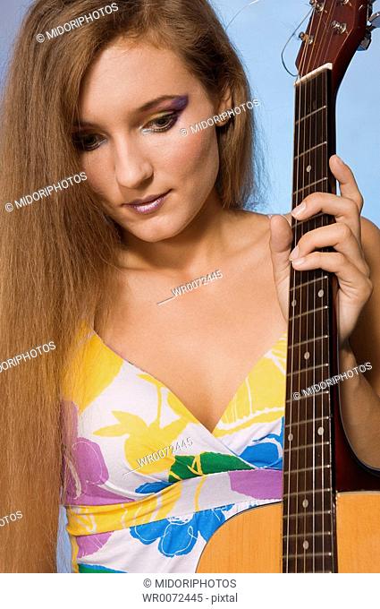 An young woman holds an guitar