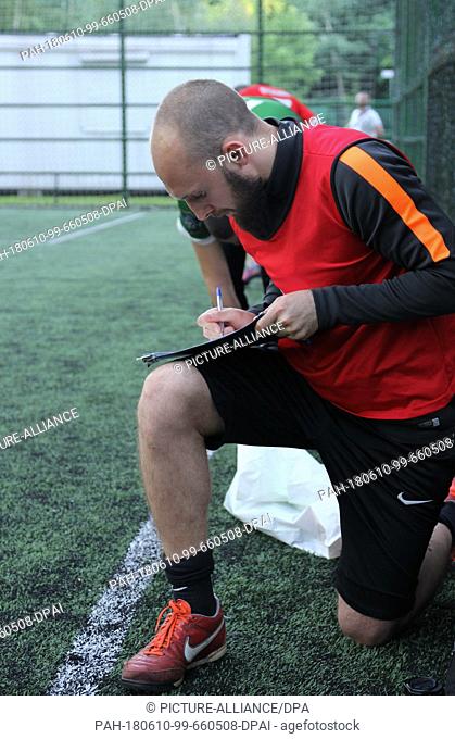29 May 2018, Russia, Moskow: Alexey Popov, founder of the business Footbic, takes notes during a soccer game at Sokolniki Park