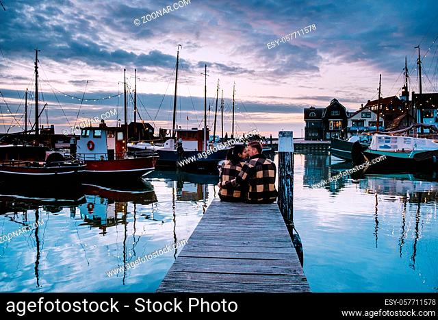 Urk Flevoland Holland, couple men and woman watching sunset at the small fishing village harbour of Urk Netherlands Europe