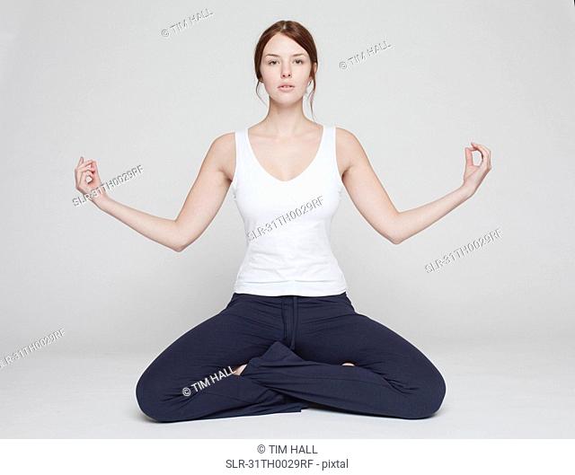 girl in lotus position on white background