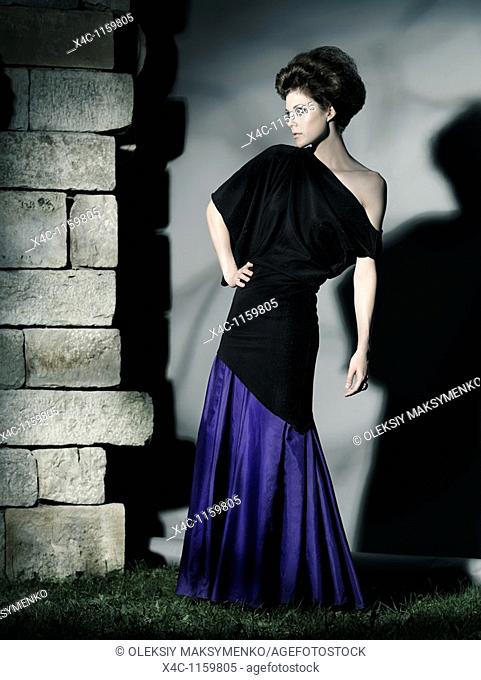 High fashion photo of a beautiful woman wearing elegant long dress