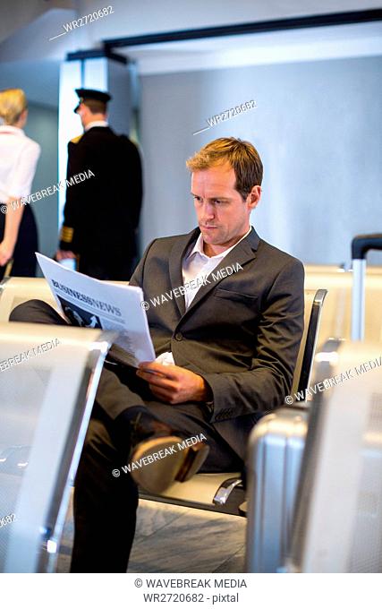Businessman reading newspaper in waiting area