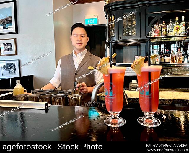 PRODUCTION - 03 October 2023, Singapore, Singapur: A bartender mixes original Singapore Slings at the world-famous Long Bar at Raffles Hotel