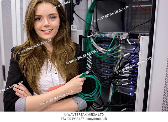 Girl holding cable in front of rack mounted servers in data storage facility