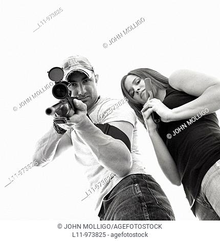 Man and women with guns; aiming at lens