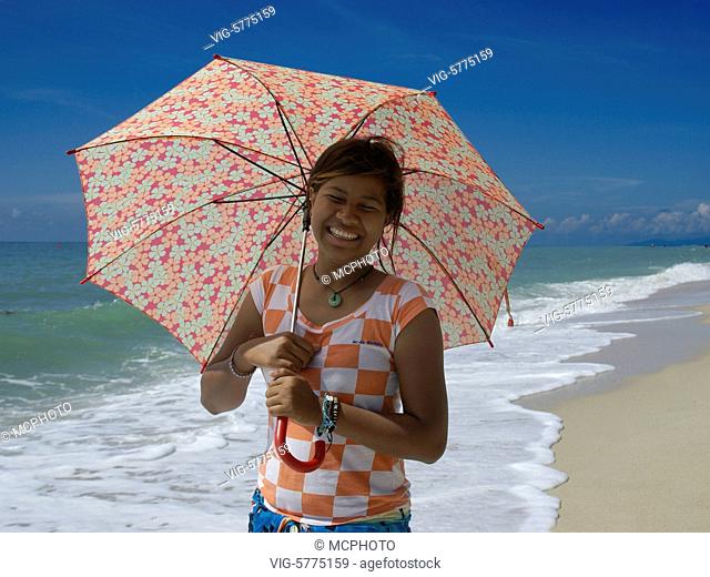 Eine junge Thailaenderin mit Sonnenschirm am Strand von Lamai auf Ko Samui, Thailand 2008| A young girl workt with a umbrella on a beach of Ko Samui - Lamai