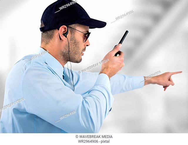 security guard with headphones and speaking with the walkie-talkie. Light blurred background