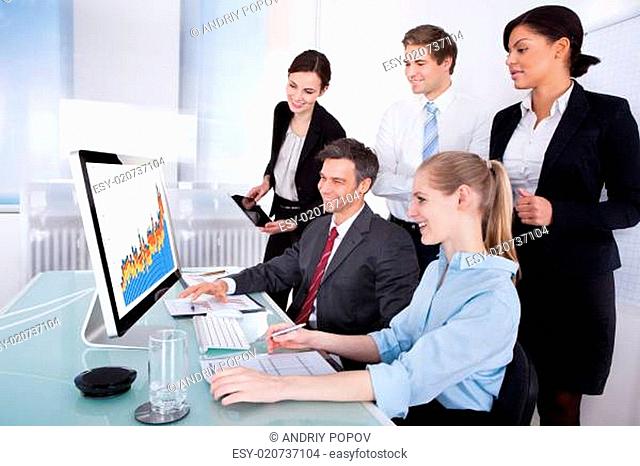 Businesspeople Looking At Graph On Computer