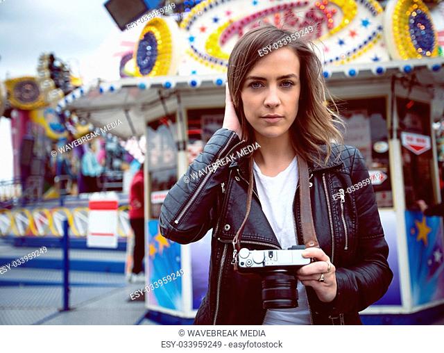 Portrait of beautiful woman holding digital camera