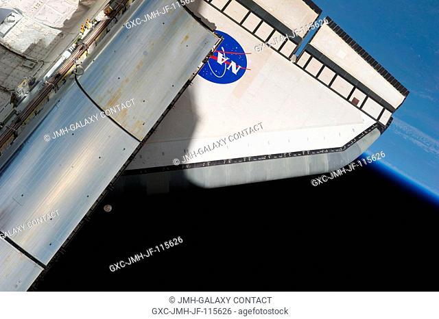 Backdropped against a scene showing Earth's horizon and the blackness of space, this image featuring the aft part of the space shuttle Endeavour was...