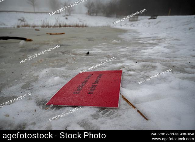 22 January 2022, Rhineland-Palatinate, Deuselbach: A sign that reads ""Do not enter ice rink, please"" sits on a frozen pond on Erbeskopf Mountain