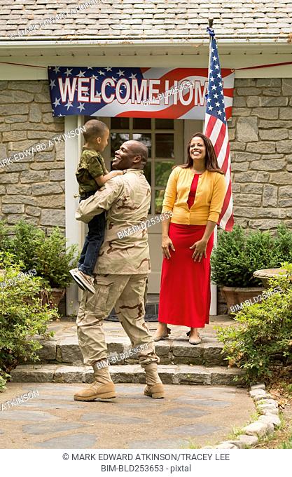 African American boy greeting returning soldier father