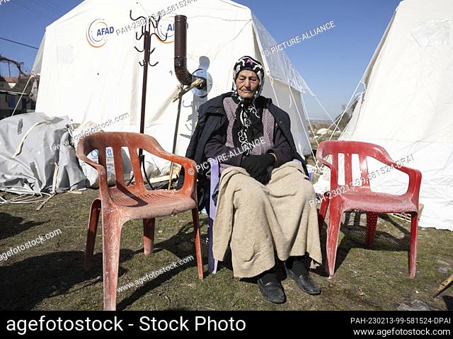 13 February 2023, Turkey, Ördekdede: 94-year-old Meyrem Yasim sits silently in front of a tent in her destroyed village. In the small village