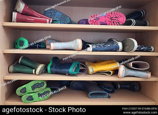 07 May 2021, Berlin: Numerous rubber boots lie in the cloakroom of a daycare center. Starting next Monday, Corona tests are to be distributed in daycare centers...