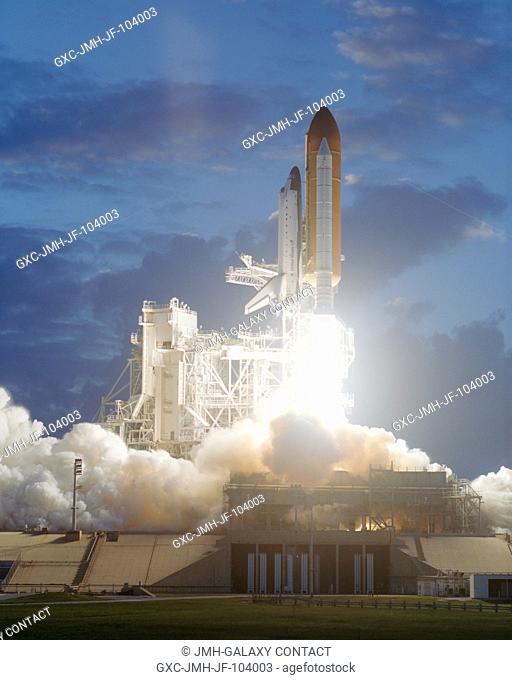 A profile perspective from a remote camera shows the Space Shuttle Endeavour as it lifts off into an afternoon sky to begin the STS-108 mission to the...