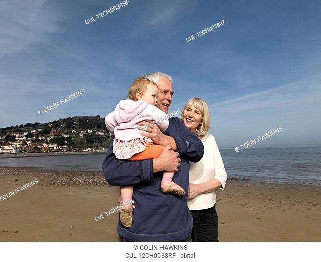 mature couple with baby on beach