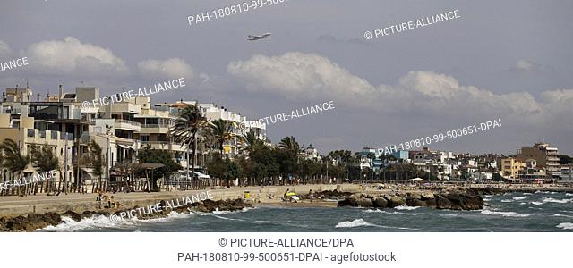 09 August 2018, Spain, Palma de Mallorca: An airplane, which took off from the island's own airport, flies over the beach Ciutat Jardi