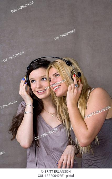 Teen girls share headphones
