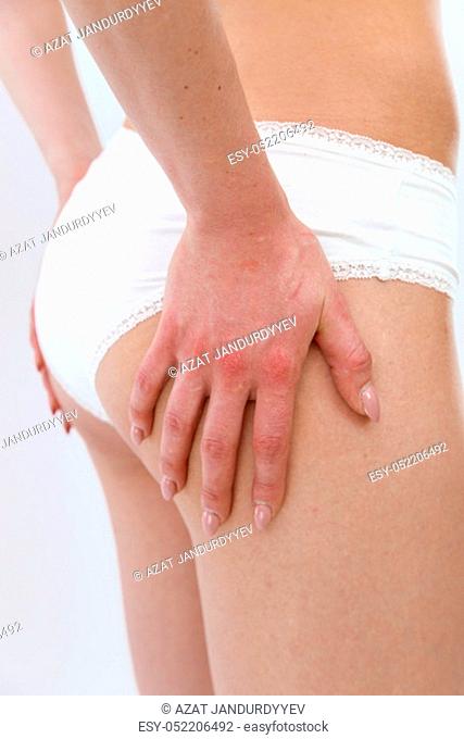 side view . a slender young sports girl in white underwear shows her figure, lifts her buttocks. isolated on a light background. without retouching.