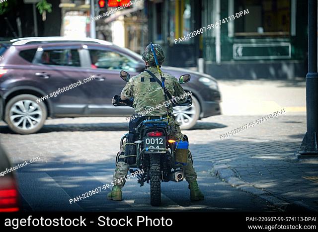 07 June 2022, Ukraine, Odessa: A Ukrainian soldier rides a motorcycle through the Ukrainian port city of Odessa on the Black Sea