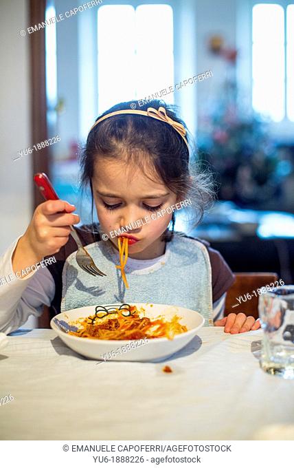 Young girl eating spaghetti