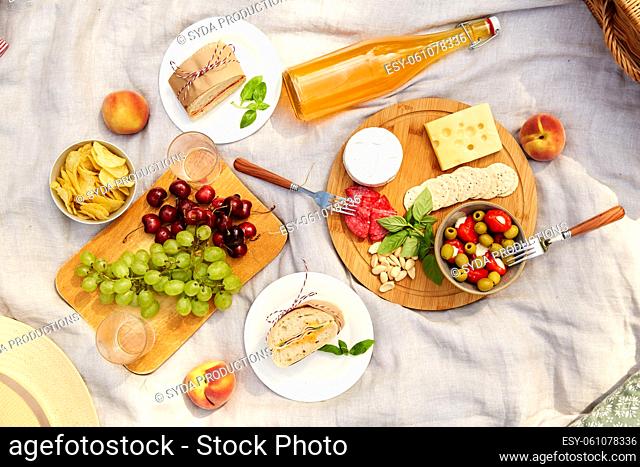 close up of food and drinks on picnic blanket