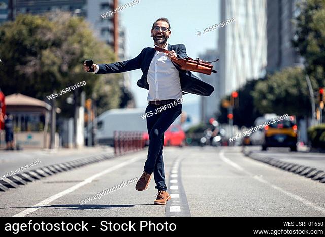 Businessman dancing on road during sunny day