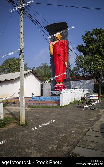 Ella, Sri Lanka A red Buddhah statue stands by the side of the road