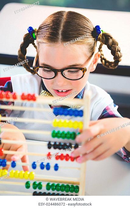 Close-up of schoolkid counting abacus in classroom