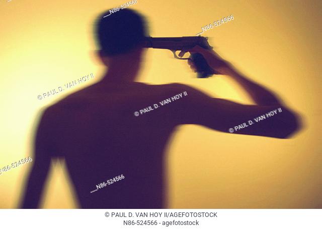 Silhouette of man with gun to his head