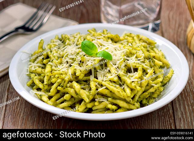 Pasta with pesto sauce and parmesan on a plate