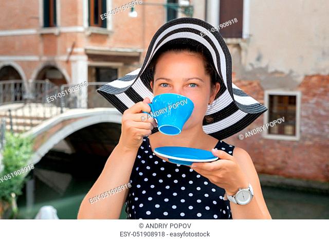 Portrait Of Beautiful Young Woman Wearing Hat Drinking Coffee From Blue Cup At Venice