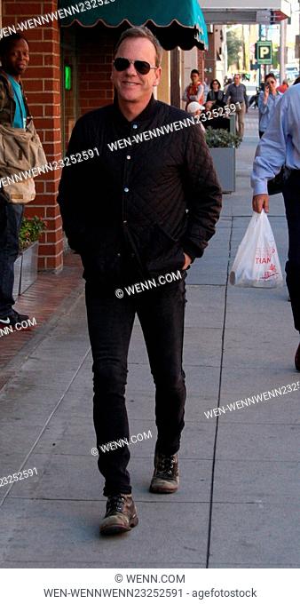 Kiefer Sutherland dressed all in black in skinny jeans and old scruffy boots out running errands in Beverly Hills wearing aviator sunglasses Featuring: Kiefer...