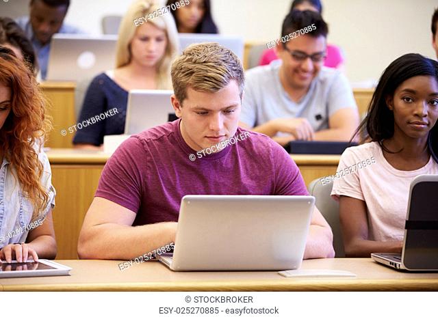 Male University Student Using Laptop In Lecture