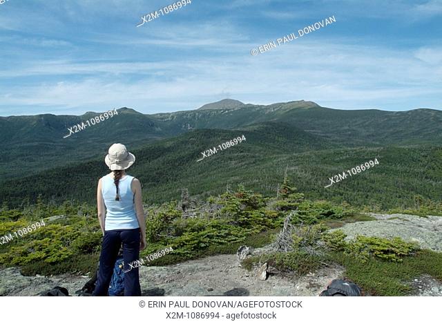 A female hiker takes in the view of Mount Washington from Mount Isolation during the summer months in the scenic landscape of the White Mountains