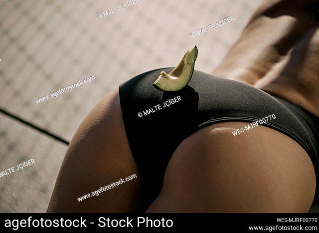 Slice of avocado on buttocks of woman