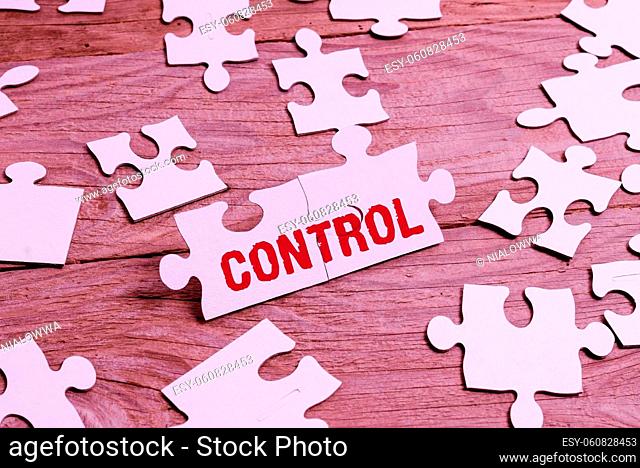 Conceptual caption Control, Business approach Power to influence direct behavior actions course of events Building An Unfinished White Jigsaw Pattern Puzzle...
