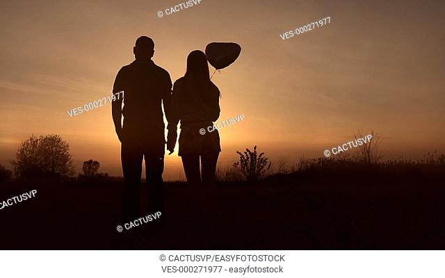 Romantic couple in love watching beautiful sunset