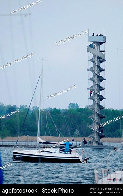 06 May 2023, Saxony-Anhalt, Bitterfeld-Wolfen: A sailboat on the Goitzsche, with the water level tower in the background