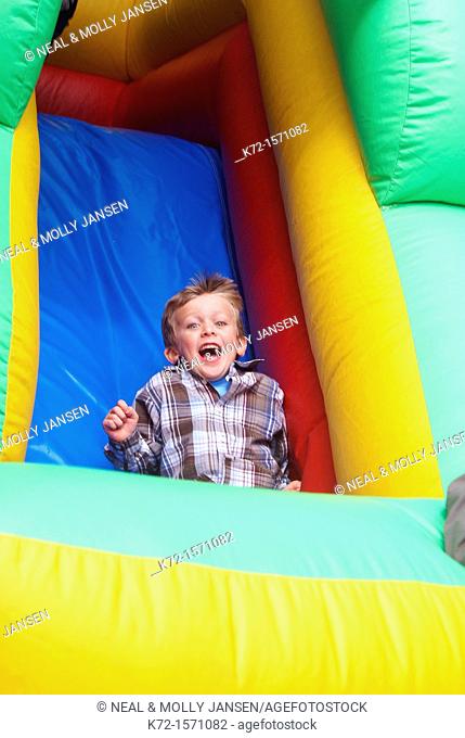 Boy sliding down an inflatable ride